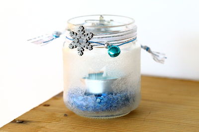 Close-up of container with snowflake on wooden table