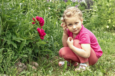 Cute girl sitting on pink flowering plants