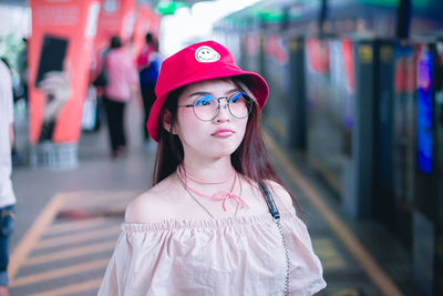 Thoughtful young woman standing at railroad station platform