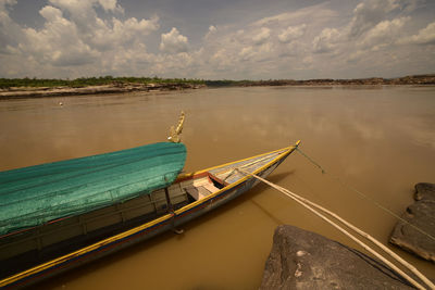 Boats moored at lake against sky