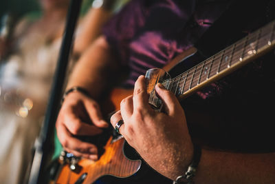 Midsection of man playing guitar