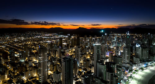 High angle view of illuminated city against sky at night