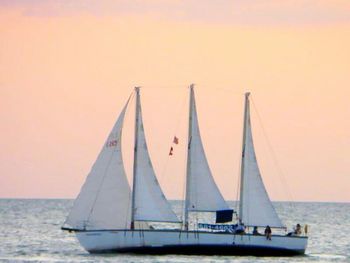 Boats in sea at sunset