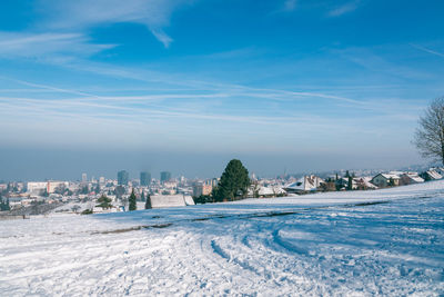 Scenic view of buildings in city against sky during winter