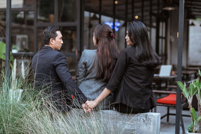 Portrait of young woman using mobile phone while standing in cafe