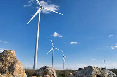 Low angle view of windmill on landscape against sky