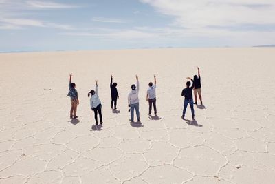 People at beach against sky