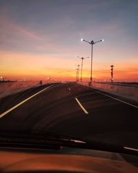 Car on street against sky during sunset