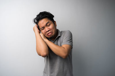 Mid adult man standing against wall