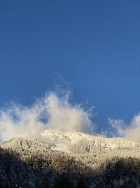 Scenic view of snowcapped mountain against blue sky