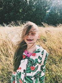 Smiling young woman standing on field