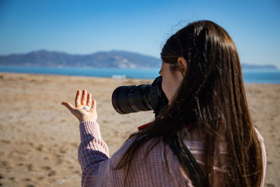 Side view of woman looking at sea against sky