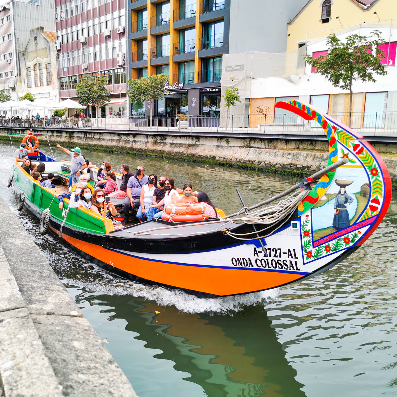 GROUP OF PEOPLE IN BOAT AGAINST RIVER