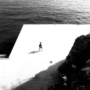 High angle view of people on rock by sea