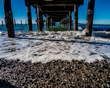 Scenic view of beach and pier against sky