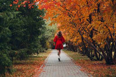 Woman walking on footpath during autumn