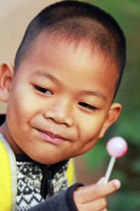 Close-up portrait of cute boy holding outdoors