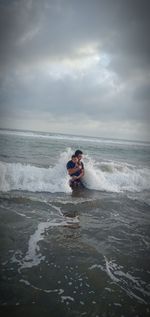 Man in sea against sky