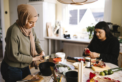 Young women preparing food in kitchen at home