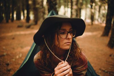 Young woman looking away sitting at forest