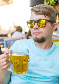 Portrait of young man drinking glass