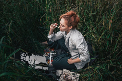 High angle view of woman sitting on field