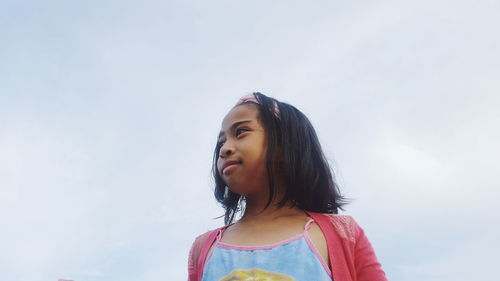 Low angle view of girl against sky