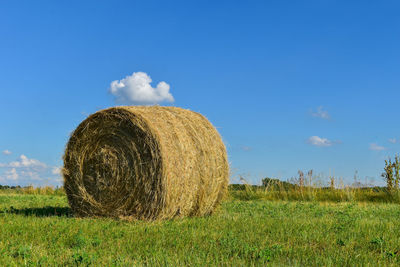 Hay bales on field against sky