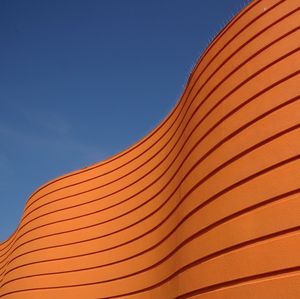 Low angle view of orange building against clear sky