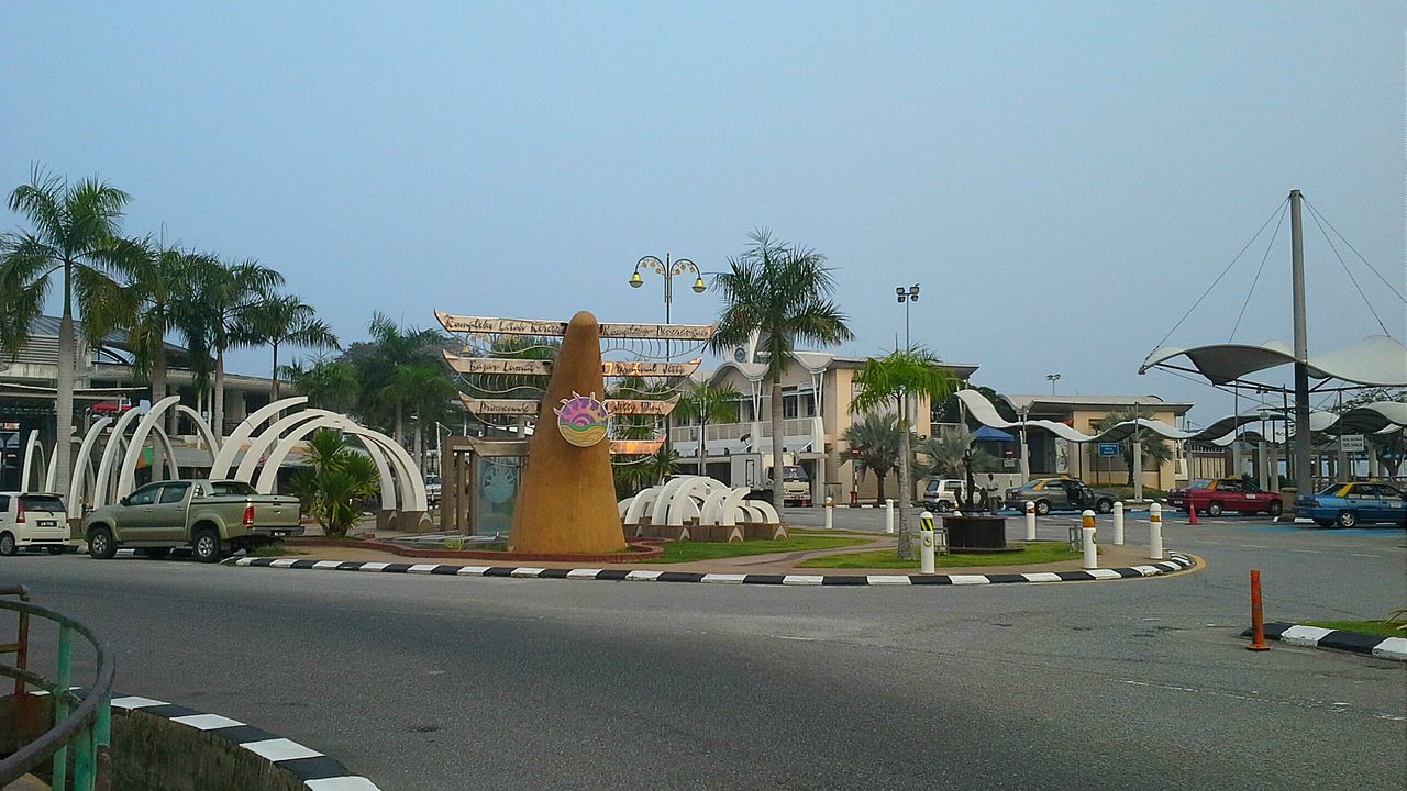 building exterior, architecture, built structure, clear sky, transportation, street, car, land vehicle, road, mode of transport, tree, palm tree, copy space, house, city, residential building, sky, residential structure, day, outdoors