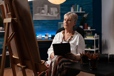 Full length of woman sitting on table