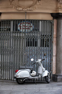 Motor scooter parked on street against building