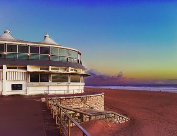 House at beach against blue sky during sunset