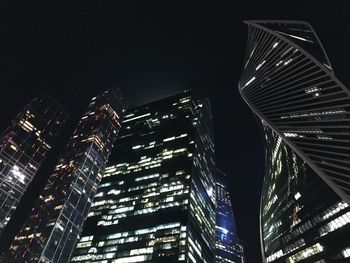 Low angle view of illuminated buildings against sky at night