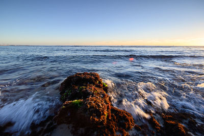 Scenic view of sea against clear sky during sunset