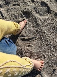 Low section of man relaxing on sand