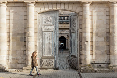 Rear view of girl standing in historic building