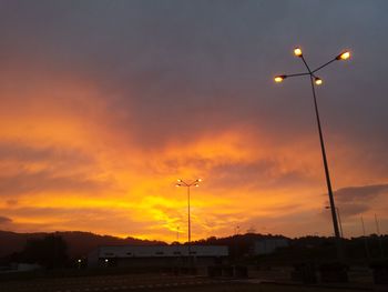 Scenic view of illuminated street light against sky at sunset