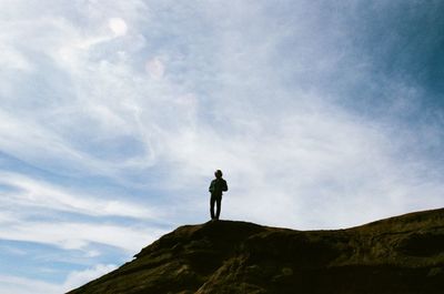Low angle view of man standing on mountain
