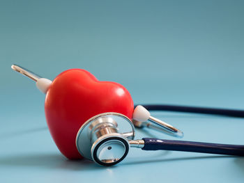 Close-up of red bell on table against blue background