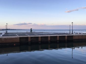 Pier over sea against sky during sunset