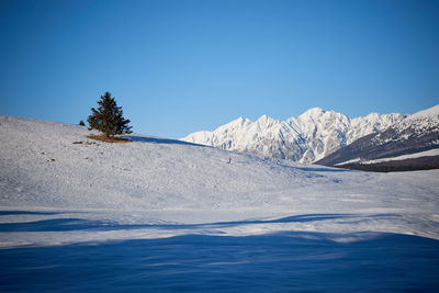 Scenic view of snowcapped mountains against clear blue sky