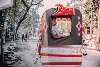 Rear view of man sitting in park during winter