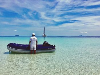 Man on boat in sea against sky