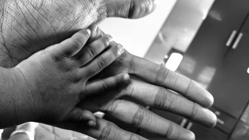 Close-up of father holding baby hand