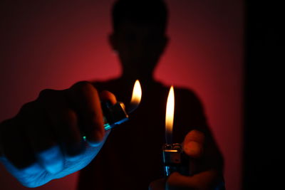 Close-up of hand holding lit candle