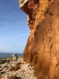 Rock formations by sea against sky