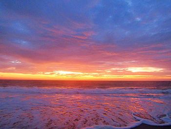 Scenic view of sea against romantic sky at sunset