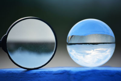 Close-up of crystal ball and magnifying glass on retaining wall