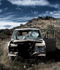 View of car wreck against cloudy sky